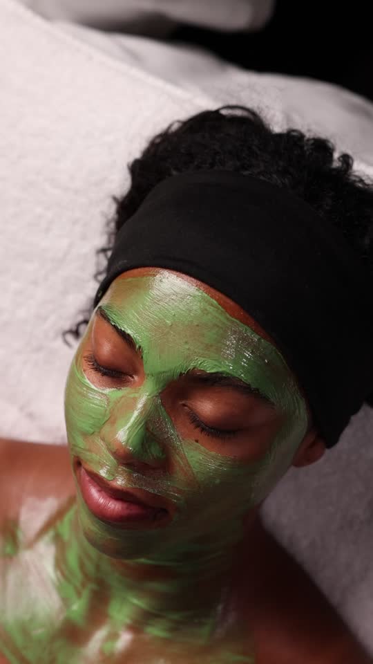 Client relaxing in a green mask